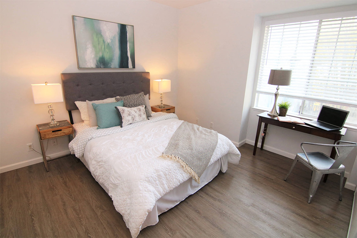 Furnished bedroom with bed, desk, and nightstands